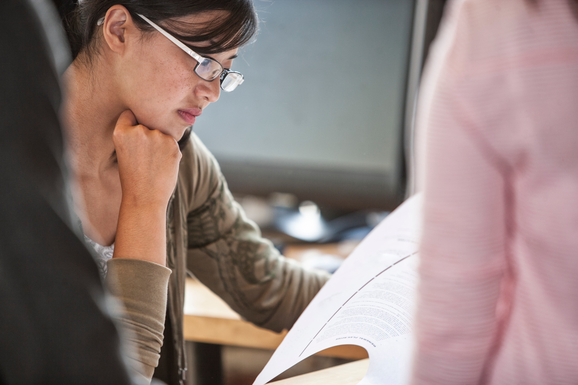 Asian woman leading an informal meeting in a creative office.